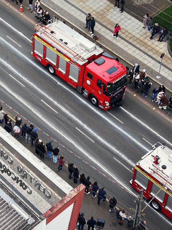 Caminhão dos bombeiros no desfile de 7 de Setembro com o público na calçada, visto do alto